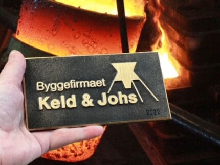 Logo for byggefirma foran smeltet metal.