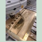 Graveringsmaskine arbejder på metalplade med stjerner.