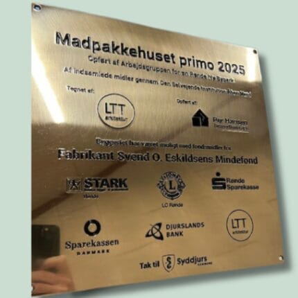 Guldplade med tekst om Madpakkehuset primo 2025.