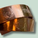 To bronzefarvede armbånd med indgraveret mønster
