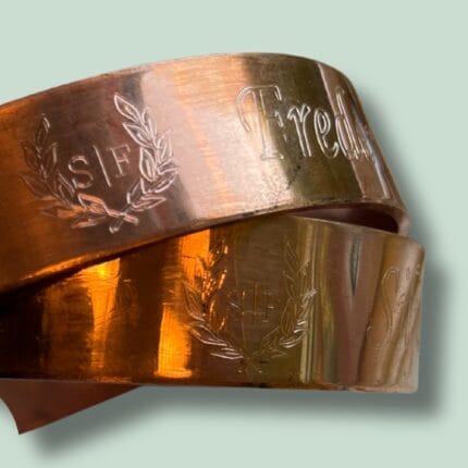 To bronzefarvede armbånd med indgraveret mønster