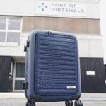 Blå Samsonite kuffert foran Hirtshals Havn-bygning.