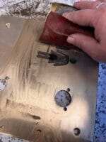 Person sliber metaloverflade med sandpapir