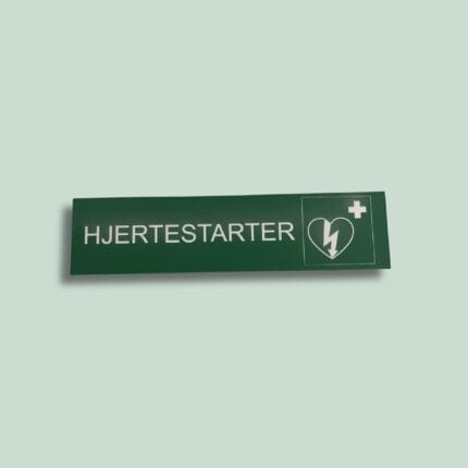 Grønt skilt med teksten 'Hjertestarter' og ikon.