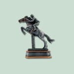 Skulptur af hest og rytter i spring